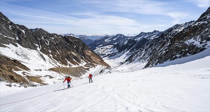 Two ski tourers walking on the rope on the glacier