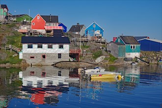 Colourful houses reflected in the water of a fjord