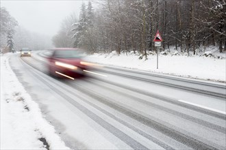 Two cars driving on snow-covered road