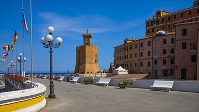 Lighthouse next to houses in pastel-coloured facades