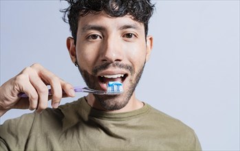 Close up of man brushing his teeth isolated