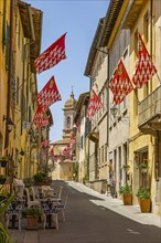 Red and white flags in the pedestrian zone of San Quirico dOrcia