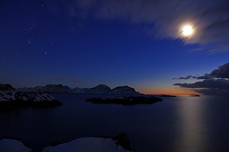 Moonlight over a wintry fjord landscape
