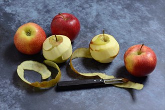 Peeled apples with peeling knife