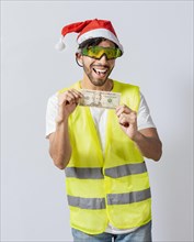 Happy builder engineer with christmas hat holding one dollar bill isolated. Happy christmas engineer showing one dollar bill