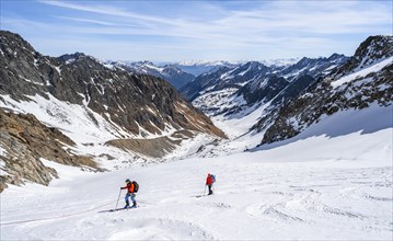 Two ski tourers walking on the rope on the glacier