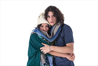 Two friends are hugging each other like they are cold while wearing the same scarf. Winter concept