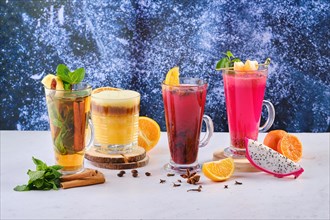 Different hot winter citrus drinks with fruits and aromatic herbs
