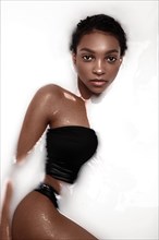 Beautiful african american woman with classic makeup in milk bath. Beauty face