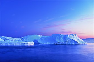 Gigantic icebergs in the light of the blue hour