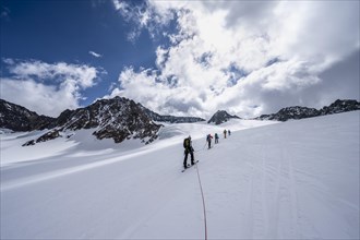 Group of ski tourers ascending on the rope