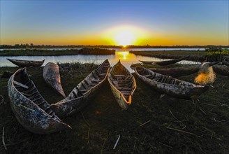 Fisherman repairs his net at sunset