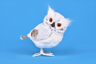 Cute fake snowy owl winter decoration on blue background