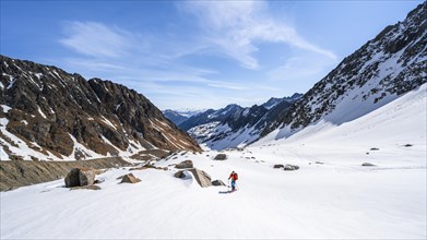 Ski tourers ascending along the glacier moraine to Berglasferner