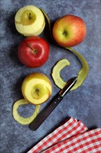 Peeled apples with peeling knife