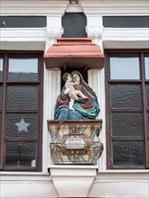 A sculpture of the Madonna and Jesus on the wall of a building in the town centre