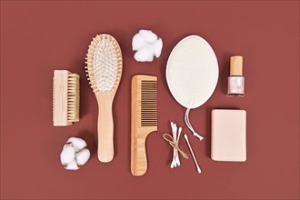 Eco friendly wooden beauty and hygiene products like comb and soap on brown background
