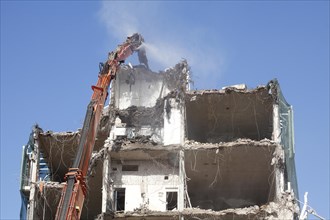 Demolition excavator and rubble of a demolished house