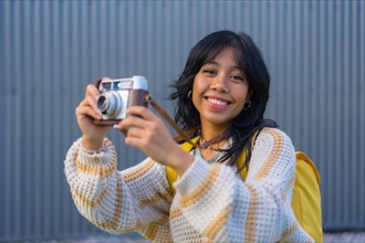 Portrait of a young Asian woman with a vintage photo camera