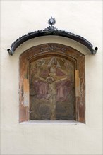 Religious oil fresco in a wall niche with canopy