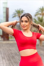 Young fit woman in red clothes doing sports in the city in spring
