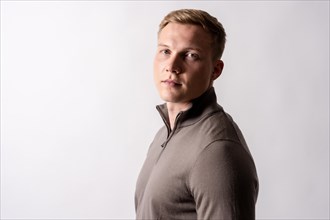 Portrait of a blond caucasian man with a brown sweater on a white background