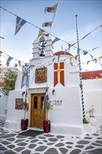 Cycladic Greek Orthodox Church decorated with flags