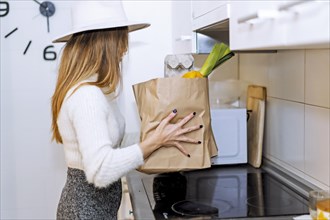 Woman coming home from the supermarket with the purchase of vegetables and fruits