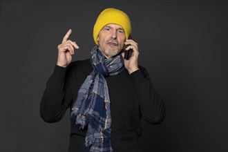 Elderly man with yellow cap on the phone