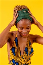 African young woman in traditional dress on yellow background