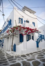 Cycladic white houses with blue shutters and bougainvillea