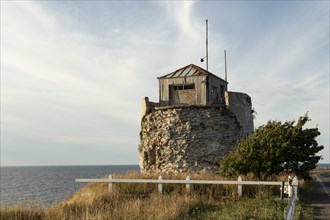 Ruin of the historic lighthouse in the evening light on the cliff on Pakri Peninsula
