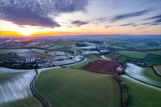 Sunset over Fields and Farms shrouded in frost from a drone