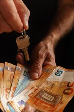 Woman handing over money and man handing over the keys to a house