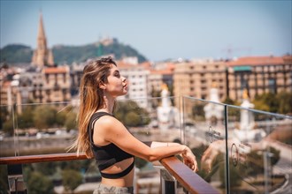 Portrait of a woman on a hotel terrace looking at the city from above