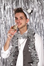 Young attractive man in a New Year's look. The photo was taken in a studio in a festive decor