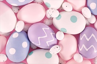Group of pastel colored easter eggs on pink background