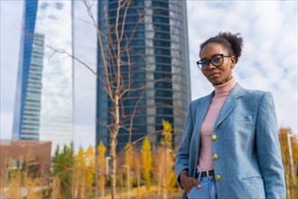 Portrait of black ethnic businesswoman wearing glasses in a business park