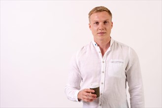 Portrait of a blond caucasian male businessman smiling with a take away coffee on a white background