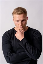 Attractive blond german model in a black sweater on a white background