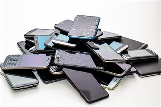 Many defective smartphones lie on top of each other in a pile