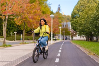 Young asian female student cycling on her way to university in europe