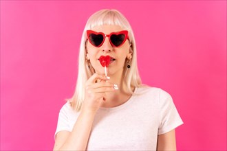 Blonde caucasian girl in studio on a pink background