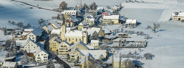 Village panorama with snow with church St. Martin