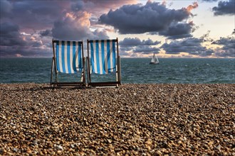 Two deckchairs by the sea