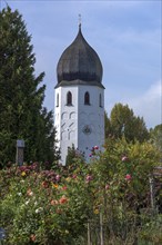 Bell tower with flower garden of the Frauenwoerth monastery church and abbey