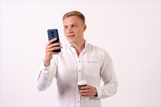 Blond caucasian businessman man smiling with a phone on a white background