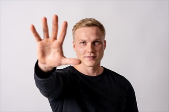 Attractive blonde german model in a black jersey on a white background