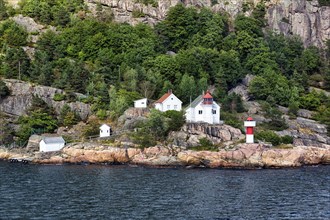 Listed red and white lighthouse on the cliffs of the Odderoya peninsula