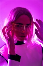 A woman in a suit and futuristic glasses with pink lights